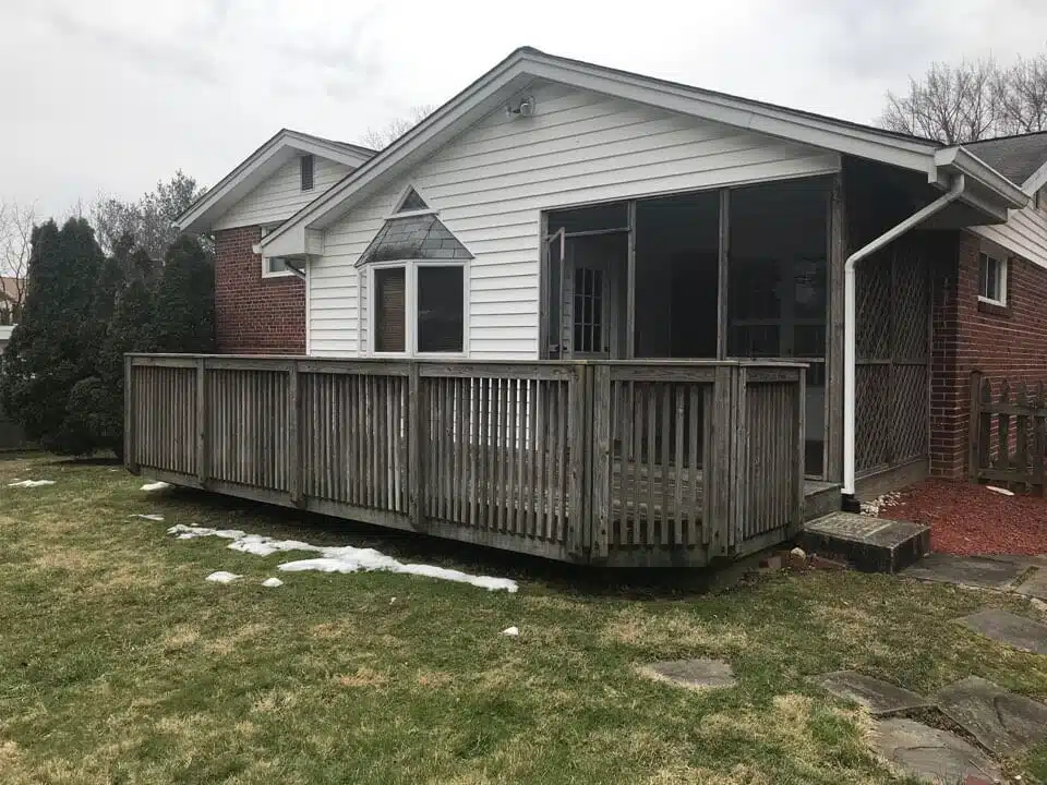 Restored wooden deck adjacent to a brick home, enhancing outdoor space and property value, showcasing professional craftsmanship by Valentine Property Services.